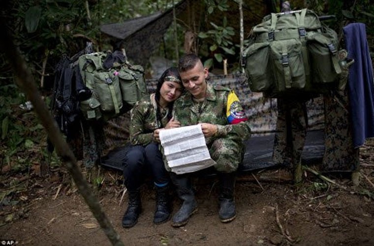 Juliana, nữ chiến binh của  quân nổi dậy Colombia FARC, ngồi cạnh bạn trai Alexis ngoài túp lều tạm của họ ở trong rừng.